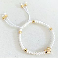 two white bracelets with gold hearts on them