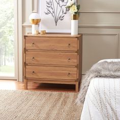 a bedroom scene with focus on the dresser and bed side table in the foreground