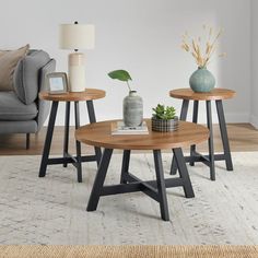 three tables sitting on top of a rug in a living room next to a couch