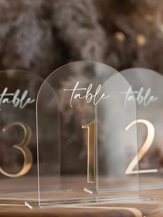 three clear acrylic table numbers are on display