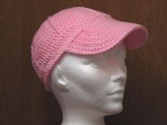 a white mannequin head wearing a pink crocheted hat on top of it