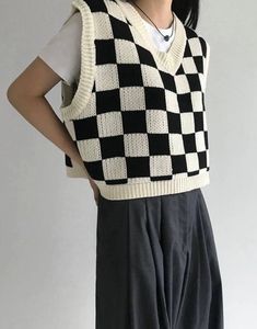 a woman wearing a black and white sweater vest