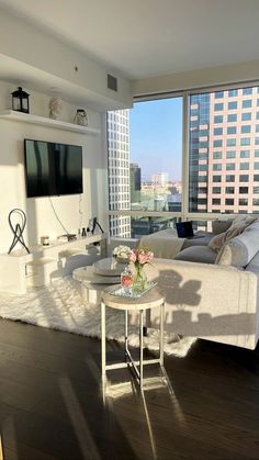 a living room filled with furniture and a flat screen tv mounted to the wall next to a window