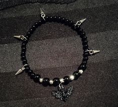 Add a little alternative goth touch to your look! (already gorgeous and unique The contrast of the black and silver pearls as well as the 5 small studs, add style to your wrist and your outfit🖤 A pretty black butterfly charm 🦋 adds the romantic finishing touch! *Elastic bracelet of approximately 18cm. *Can be customized and made smaller or larger: leave me the desired size in a message. *6mm and 4mm black agate beads *4mm silver plated hematite beads. *Black butterfly charms in black metal all Goth Bead Bracelet, Edgy Black Bracelet For Festivals, Edgy Black Bracelet For Festival, Edgy Black Festival Bracelet, Black Grunge Bracelets For Festivals, Alternative Style Black Bracelets As Gift, Adjustable Black Grunge Bracelet, Black Alternative Style Bracelet For Festivals, Alternative Style Black Bracelet Gift