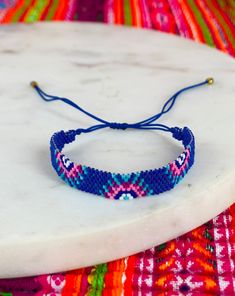 a blue beaded bracelet sitting on top of a white surfboard