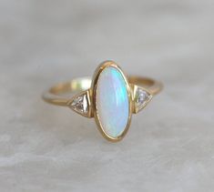 Gorgeous one of a kind Australian oval opal & diamond ring perfect as a wedding or engagement ring. Available in 18k yellow gold as seen online. If you would prefer other gemstones, please contact us before purchase regarding pricing. Item details: genuine top quality Australian opal diamond total carat weight - 0.22ct, color F-G, VS clarity 18k yellow gold 1.8mm band The ring will be shipped in a gift box with insured express shipping. Signature required. Thank you for visiting my shop! May Luxury Classic Opal Ring With Center Stone, Ethiopian Opal Oval Ring For Wedding, Oval Opal Ring With Rose Cut Diamonds, Elegant Ethiopian Opal Ring For Anniversary, Ethiopian Opal Ring For Wedding, Classic Opal Ring With Diamond Accents, Classic Oval Opal Ring With Diamond Accents, Elegant Opal Ring With Rose Cut Diamonds, Heirloom Oval Opal Ring With Accent Stones