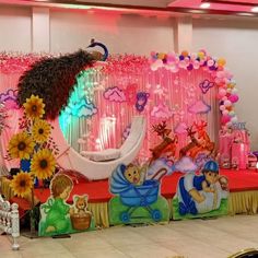 an elaborately decorated stage with flowers and balloons on the wall, along with other decorations