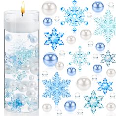 a candle and some snowflakes are next to each other with balls in it