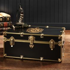 a black trunk sitting on top of a wooden table