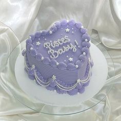 a purple birthday cake on a glass plate