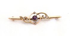 "A 15 karat gold bar brooch, set with a faceted, round amethyst of .30 carats and 12 white seed pearls.  It was made in England in the late 19th to early 20th century.  Included is its original hinged, fabric covered wood case, the retailer ink stamp on the silk lid lining being \"M. Spiegelhalter & Son, Watchmaker to the Admiralty, Malton.\"  Malton is a town in Yorkshire.   CONDITION:  The brooch is in very good condition.  Slight bends to the brooch and its pin.  The case has a broken latch and significant wear to the fabric." Elegant Gold Amethyst Brooches, Elegant Purple Brooches For Anniversary, Bar Brooch, Wood Case, Ink Stamps, A Town, Seed Pearl, Gold Bar, Fabric Covered