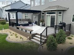 an outdoor deck with patio furniture in the back ground and landscaping around it, surrounded by grass