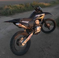 a dirt bike parked on top of a dirt road