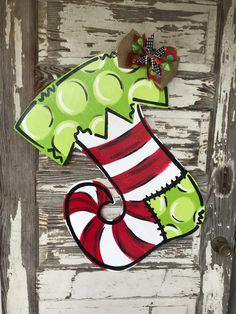 a christmas stocking door hanger on the side of a wooden door with a candy cane