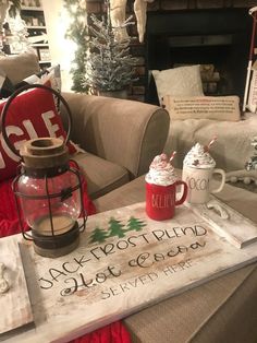 a coffee table with two mugs and a sign on it