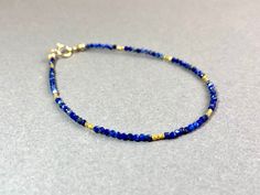 LAPIS LAZULI BRACELET IN GOLD FILLED AND VERMEIL This pretty bracelet, made from dark blue Lapis Lazuli beads has a length of 17.5cm.  If you like another length, please specify when ordering. I send all my jewelry packaged in a small jewelry pouch. MATERIAL Lapis Lazuli beads 1,7 mm 14K Gold filled Clasp Vermeil beads (silver goldplated) 1,5mm Adjustable Sapphire Bracelets With Gemstone Beads, Adjustable Sapphire Bracelet With Gemstone Beads, Gold Beaded Lapis Lazuli Bracelets, Adjustable Lapis Lazuli Jewelry With Faceted Beads, Spiritual Gold Friendship Bracelets With Gemstones, Blue Hand Wrapped Bracelets For Everyday, Everyday Blue Hand Wrapped Bracelets, Hand-strung Gold Lapis Lazuli Bracelets, Gold Gemstone Beads Friendship Bracelets For Gift