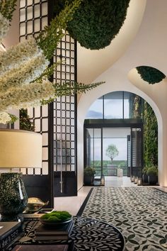 the entrance to an elegantly decorated living room with large windows and potted plants