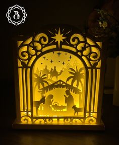 an illuminated nativity scene with the birth of jesus and baby jesus in silhouettes