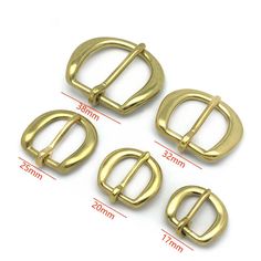 four gold metal buckles with measurements