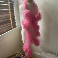 a mannequin with pink ruffles on it in front of a window