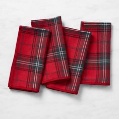 three red and black plaid napkins sitting on top of a white countertop next to each other