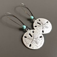 "Silver Sand Dollar Earrings - Antiqued Silver Sand Dollar accented with a small glass Turquoise bead on the earwires. The Sand Dollar is approximately 23mm (slightly smaller than US quarter). Silver plated Earwires Earrings measure just over 2.25\" from top of earwire to bottom of sand dollar More sand dollar jewelry can be found here: https://www.etsy.com/shop/mcstoneworks?search_query=sand+dollar" Silver Dangle Earrings For Vacation, Adjustable Jewelry With Matching Earrings For Vacation, Adjustable Matching Earrings For Vacation, Silver Dangle Earrings For The Beach, Silver Drop Earrings For Vacation, Beach Jewelry With Matching Earrings In Silver, Nickel-free Silver Earrings For Vacation, Silver Ear Wire Earrings For Beach, Nickel-free Round Earrings For Beach