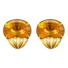 The earrings is finely crafted in 18k yellow gold with diamonds weighing approximately total of 0.50 and citrine as a center stone and weighing approximately total of 30.00 carat.