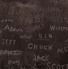 graffiti written on the side of a blackboard with writing all over it, including names and phrases