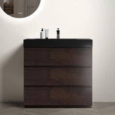 a bathroom vanity with a round mirror above it