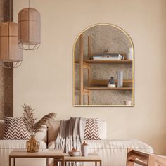 a living room filled with furniture next to a wall mounted mirror on the side of a wall