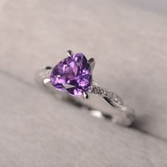 a purple heart shaped ring with diamonds on it