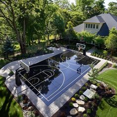 an aerial view of a basketball court in a backyard with trees and shrubs surrounding it