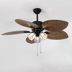 a ceiling fan with three lights hanging from it's center blade and two leaves attached to the blades