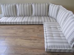 a striped couch sitting on top of a hard wood floor