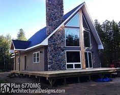 a house with a stone chimney in the middle of it's front yard and deck