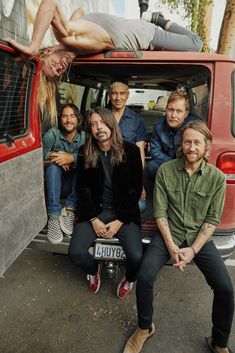 a group of people that are sitting in the back of a van and posing for a photo