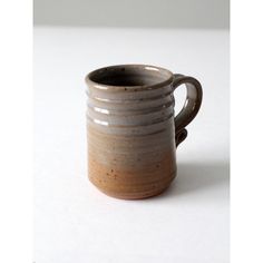 a brown and white cup sitting on top of a table