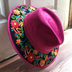 Stand out with this beautiful handcrafted Mexican Suede Hat with beautiful detailed floral embroidered canvas brim. Perfect accessory to add that with that daily outfit. MADE IN MEXICO By: Mexican Artisans For: Women Size: Medium 23' Color: magenta | black | multi Details: Top Suede Embroidered canvas brim Inner elastic band Contact us for more details PLEASE READ BEFORE PURCHASE: The picture is an ACCURATE REPRESENTATION.Colors in the pictures may vary a little by effects of light. Each product Cheap Embroidered Red Hats, Pink Bohemian Fedora For Spring, Spring Festival Embroidered Hat, Pink Embroidered Hats With Curved Brim, Pink Embroidered Hat With Curved Brim, Traditional Fedora For Festivals, Embroidered Brimmed Spring Hats, Summer Festival Hat With Floral Embroidery, Pink Short Brim Felt Hat For Festival