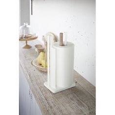 a kitchen counter top with a paper towel dispenser and fruit on it