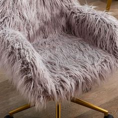 a furry chair with gold legs on a wooden floor