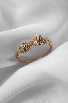 Drops of pearl moonlight, nestled in the most ethereal blooms and plucked from a dream. Hand-carved, with intricately layered unfurling petals of gold. An enchanted heirloom, gracing your finger. Available in 14k yellow, rose, white, or champagne goldOne 8mm seed pearlTwo 1-1.2mm seed pearlsTwo 1.7-1.9mm seed pearls Your piece will be made-to-order—please allow 4 to 6 weeks for us to create the piece before shipping to you. If you require a quarter size or a size not listed on our dropdown menu, Heirloom Jewelry Ideas, Ethereal Wedding Rings, Cottage Core Engagement Ring, Cottage Core Wedding Ring, Cottagecore Wedding Ring, Ethereal Engagement Ring, Whimsical Wedding Ring, Pearl Wedding Rings, Beautiful Jewelry Vintage