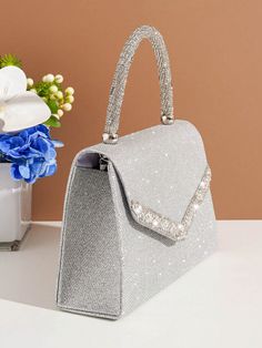 Introducing the perfect accessory for the party perfect bride - the Shimmer and Shine: Glitter Handbag. Made with glimmering glitter, this handbag will add a touch of sparkle to any wedding ensemble. Stay stylish and organized with this must-have bag. Color : Silver Details : Rhinestone Magnetic : Yes Strap Type : Chain Style : Glamorous Pattern Type : Plain Bag Size : Small Closure Type : Magnet Type : Square Bag Material : Glitter Composition : 100% Polyester Care Instructions : Do not wash Size Bag Height Bag Length Bag Width Handle Height Strap Length one-size 14.5 22 7 9 120 Glamorous Silver Glitter Clutch, Glamorous Evening Clutch With Glitter, Glamorous Glitter Clutch For Evening, Handheld Sequins Party Bag, Glitter Clutch Evening Bag Gift, Glitter Clutch Evening Bag For Event, Glitter Clutch Evening Bag For Events, Elegant Glitter Evening Bag As Gift, Glamorous Sparkling Bags For Party