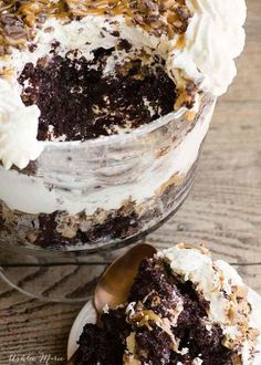 a close up of a cake with frosting and toppings on a wooden table