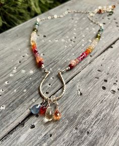 If you're looking for a handmade gift, this beautiful, delicate artisan necklace contains a full rainbow of gemstones! Ruby, sunstone, citrine, tourmaline, topaz, fire opal, apatite, sapphire and more form a gemstone rainbow strand. In the center, a sterling silver horseshoe holds sparkling briolettes of sapphire, citrine and zircon.  Necklace measures 15.5 to 17.5 inches with a 2 inch extender chain. Horseshoe is about 1 inch long, total drop length (horseshoe and briolettes) is about 1.5 inches.  This piece is one of a kind, and you will receive the exact necklace pictured. Necklace care: To protect the delicate gemstones, please handle with care. Remove before showering or bathing, exercising, or applying lotion, perfume, or sunscreen. Silk may stretch when wet, so please keep dry, and Dangle Sterling Silver Necklaces With Gemstone Accents, Sterling Silver Necklaces With Gemstone Accents In Dangle Shape, Sterling Silver Teardrop Necklace With Gemstone Accents, Dazzling Sterling Silver Necklaces With Gemstone Accents, Dainty Sterling Silver Necklace With Gemstone Accents, Sterling Silver Necklace With Briolette Gemstone Accents, Bohemian Sterling Silver Briolette Jewelry, Sterling Silver Birthstone Necklace With Briolette Gemstone, Briolette Birthstone Necklace In Sterling Silver