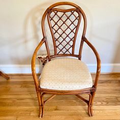 a small dog is sitting on the floor in front of a chair that has been made out of bamboo