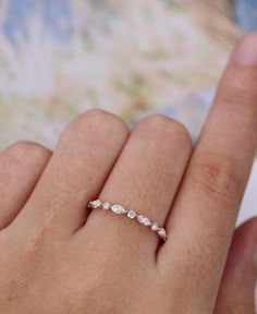 a woman's hand with a diamond ring on top of her finger and the other hand holding it