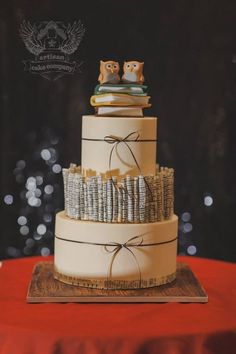 a three tiered wedding cake with owls on top