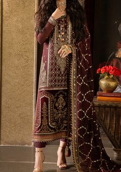 Introducing our Winter collection 'VELVET FESTIVE' by Asim Jofa designed to make you look and feel your best these pieces will add a touch of class and elegance to your wardrobe. Step into the embrace of timeless maroon, where elegance is not just a choice, but an effortless exhalation. This ensemble is a celestial canvas adorned with a constellation of 9mm gold sequins, twinkle-sized 3mm antique gold sequins, and a harmonious blend of matching zariwork and lurex, together weaving a tapestry of pure enchantment. The long shirt is a saga of opulence, embroidered from the neckline down to the very hem, an echo of grandeur that dances in harmony with the matching dupatta. The velvet-clad daman border is like a sentinel of sophistication. This is more than just an outfit, it's a time-honored t Readymade Saree, Silk Trousers, Clothing Websites, Gold Sequins, The Embrace, Embroidered Neckline, Silk Dupatta, Model Pictures, Dress 100