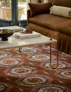 a coffee table with two books on it and a bowl of nuts in front of it