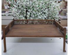 a wooden bench with white flowers in it